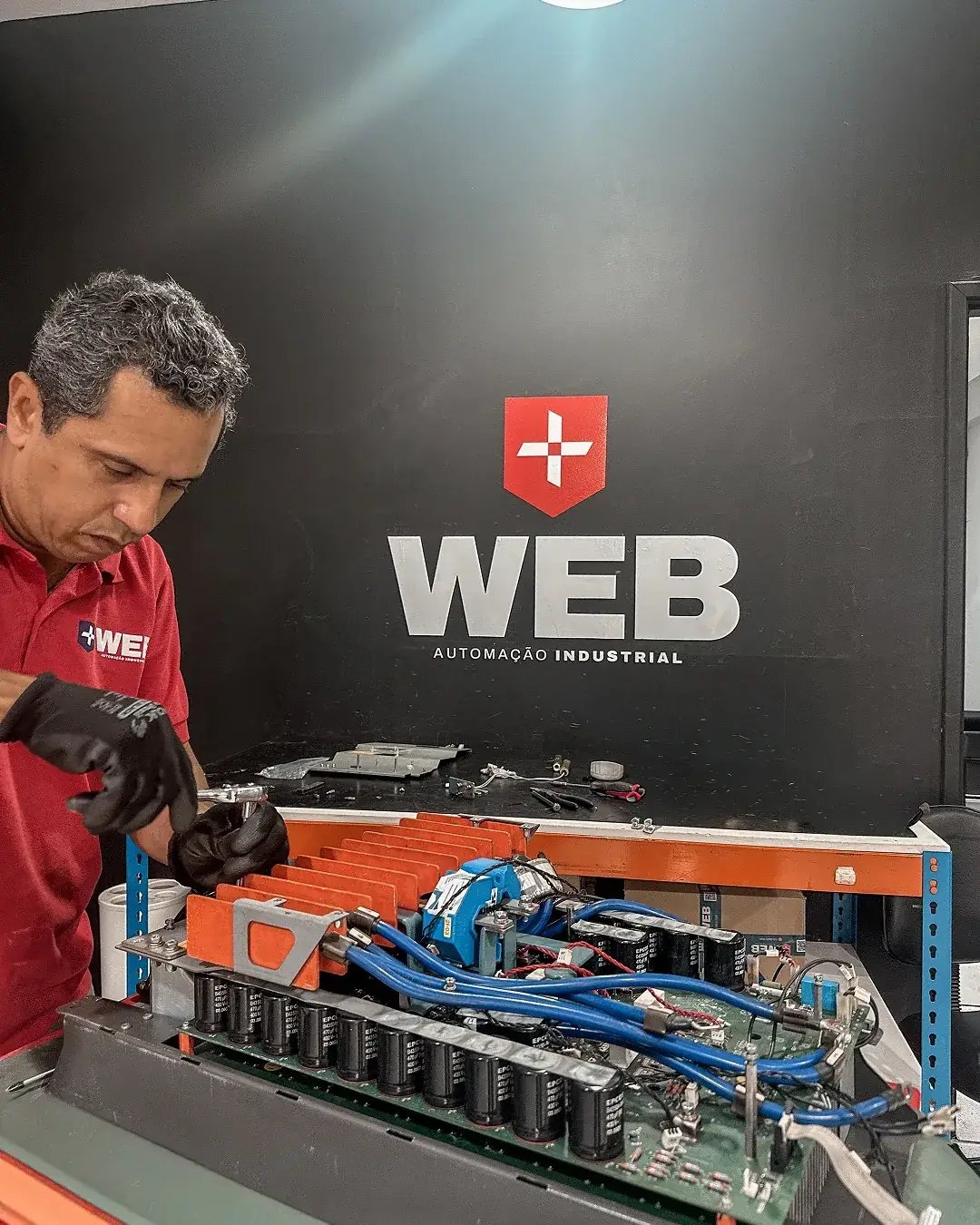 Técnico da WEB Automação Industrial reparando um equipamento na bancada