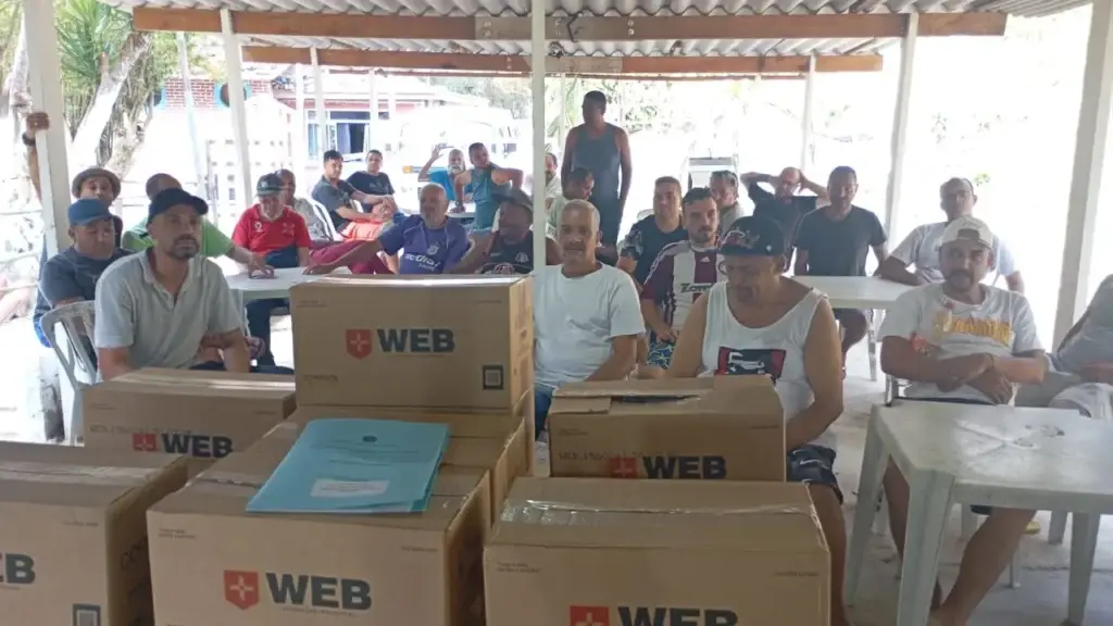 Cestas básicas da Corrente do Bem sobre as mesas durante uma ação com a comunidade