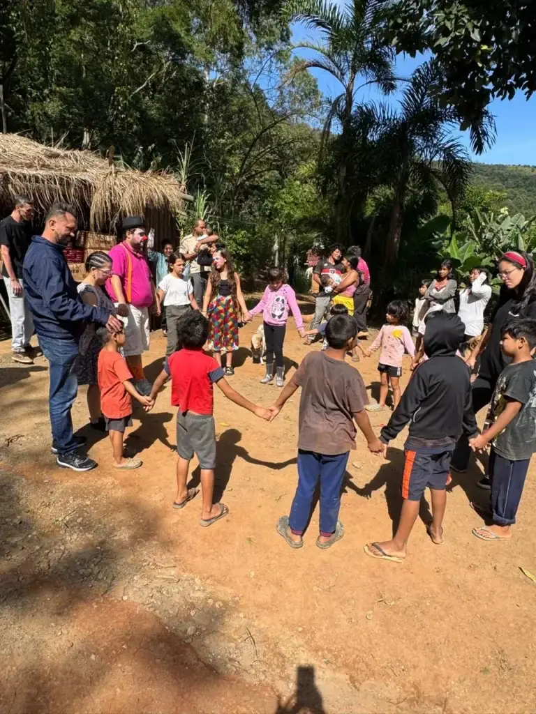 Crianças e voluntários em roda durante a ação nas Aldeias do Jaraguá